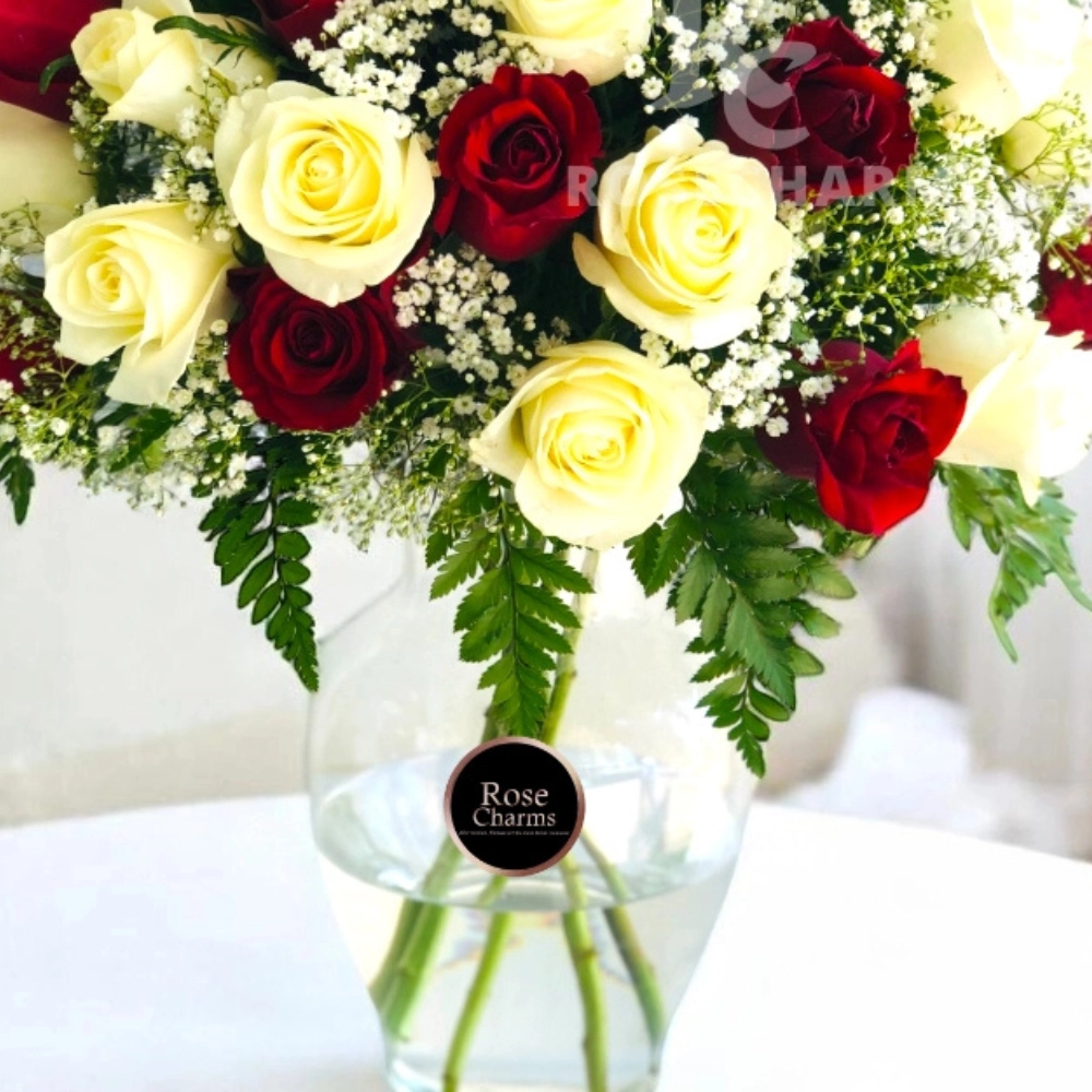 Arrangement of red and white roses in a glass vase