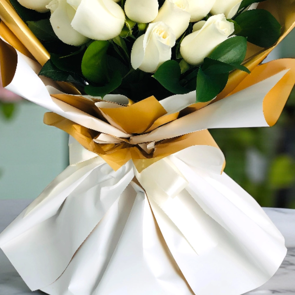A bouquet of 25 white roses with fillers in a nice wrapping