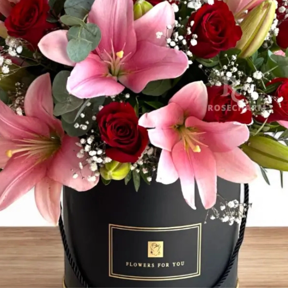 Arrangement of red roses & pink lilies in a box