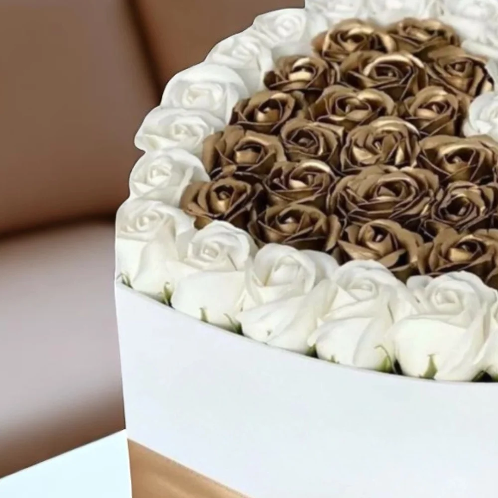 Hearts shape white and gold rose arrangement in a box
