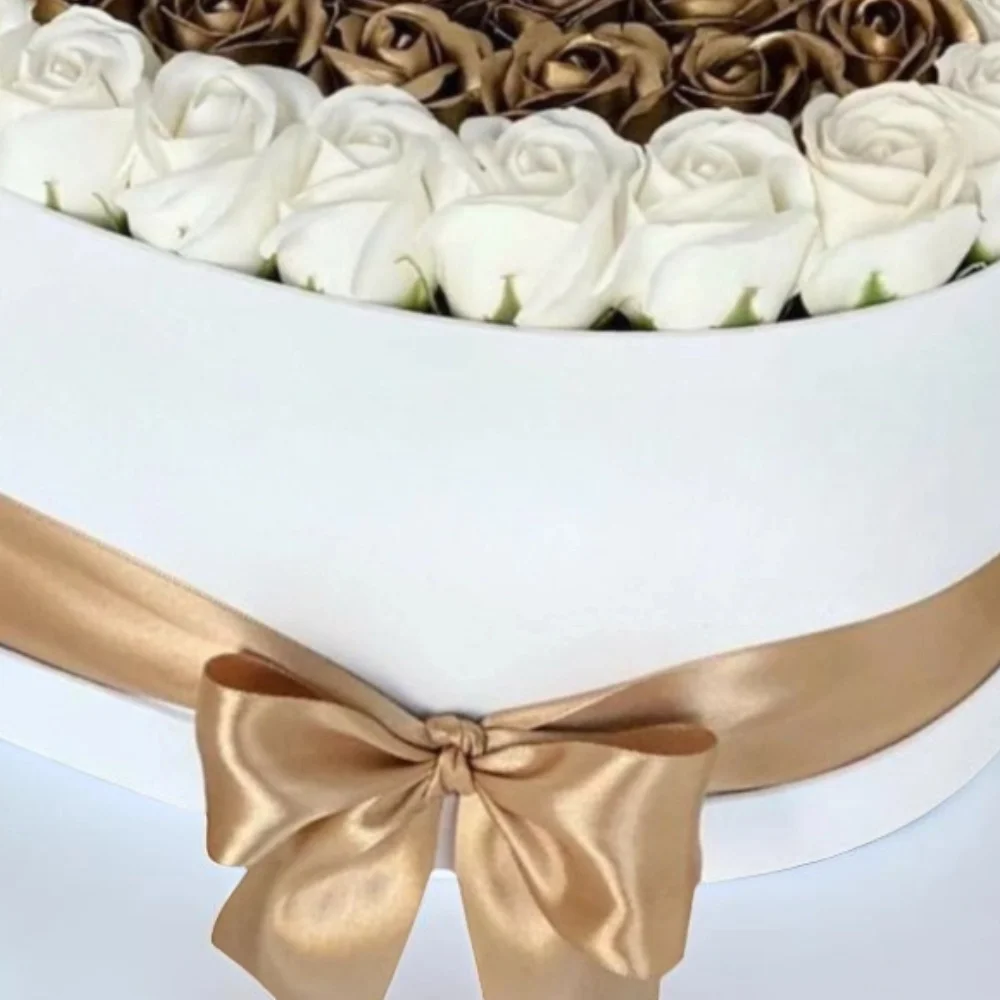 Hearts shape white and gold rose arrangement in a box