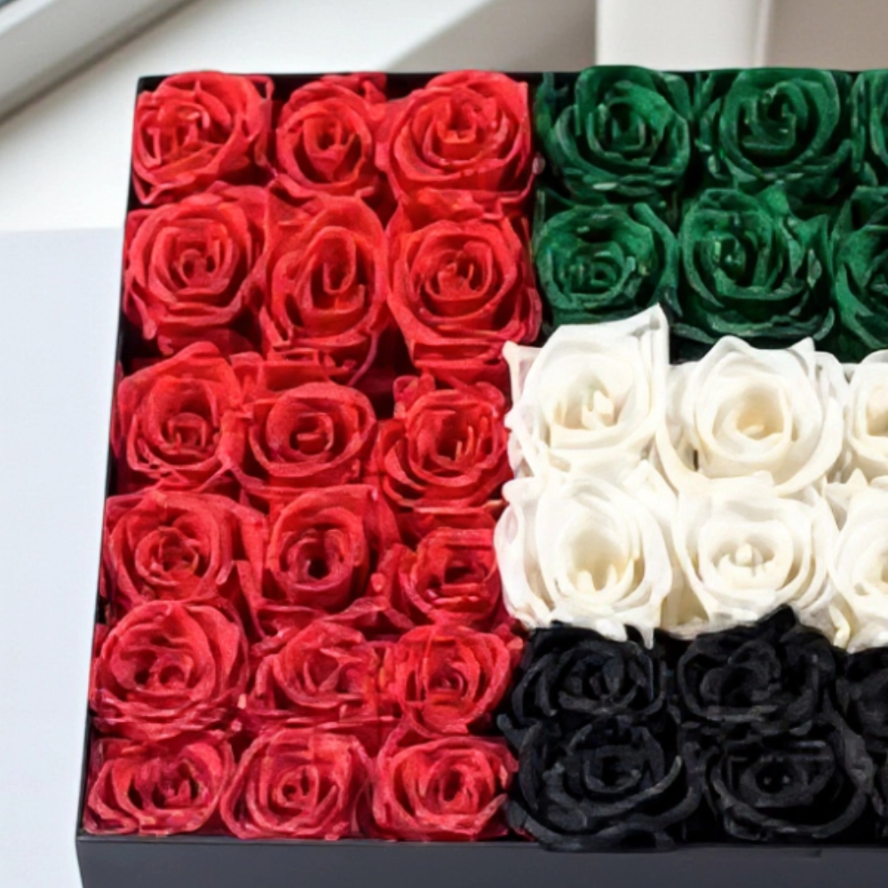 Arrangement of 50 - 60 UAE flag color roses in a black box