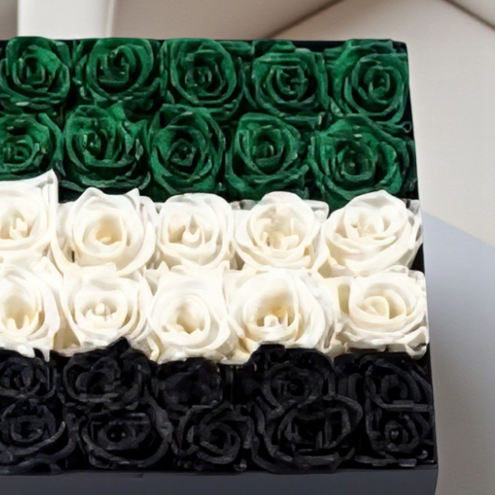 Arrangement of 50 - 60 UAE flag color roses in a black box
