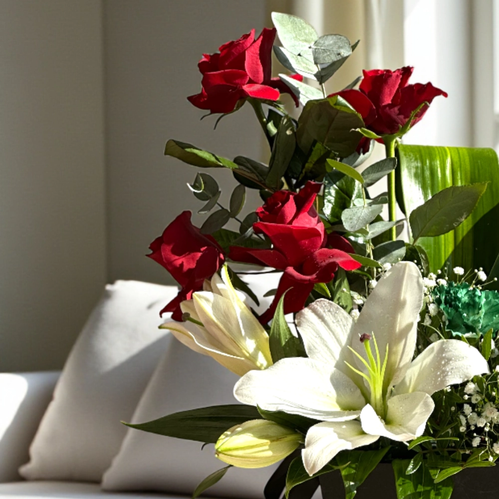 Arrangement of UAE color lilies and roses in a box